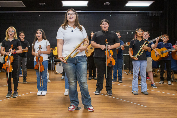 Band lead by trumpeteer with violins and guitars.