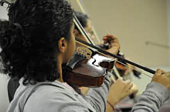 Students play violins.